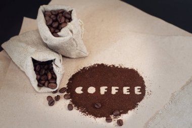 Kağıt üzerinde tuval çanta ve zemin kahve kahve çekirdekleri.