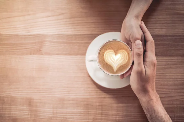 Casal de mãos dadas com café — Fotografia de Stock