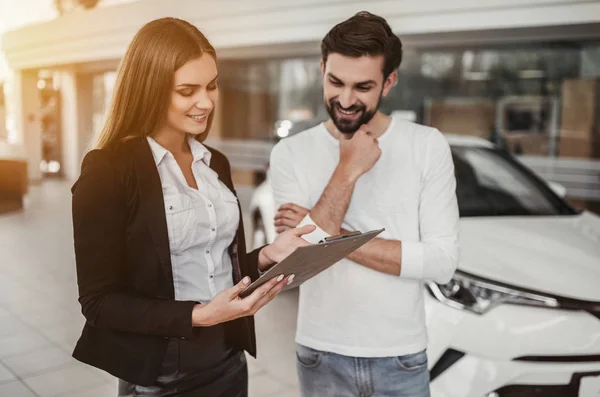 Vendedor con cliente en concesionario de coches — Foto de Stock