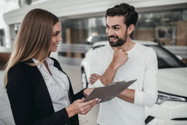 Verkoper met klant in autodealer — Stockfoto