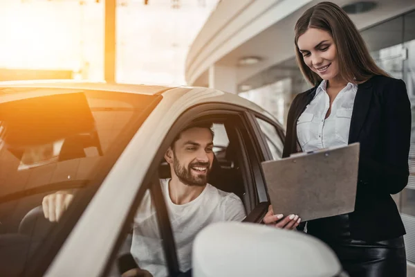 Salesperson with customer in car dealership — Stock Photo, Image