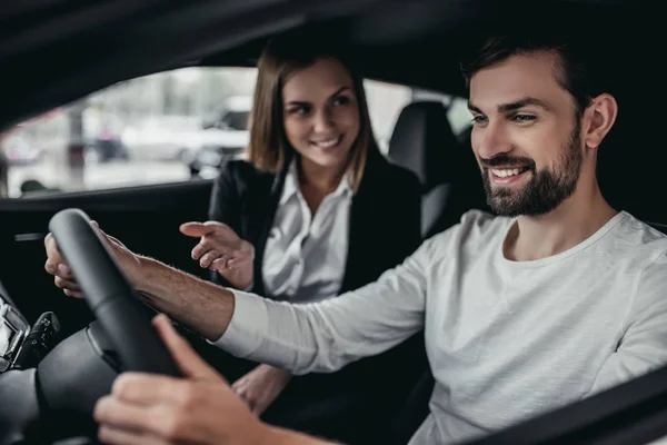 Vendedor com cliente na concessionária de carro — Fotografia de Stock