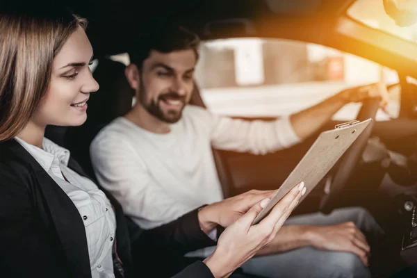 Vendedor con cliente en concesionario de coches — Foto de Stock