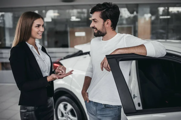 Vendedor con cliente en concesionario de coches — Foto de Stock