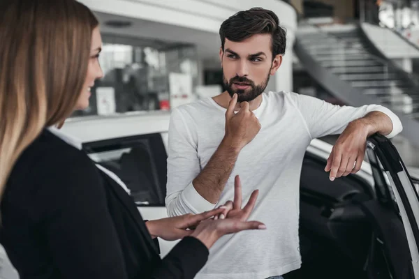 Vendedor con cliente en concesionario de coches — Foto de Stock