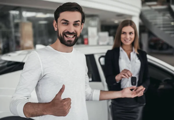 Vendedor con cliente en concesionario de coches — Foto de Stock