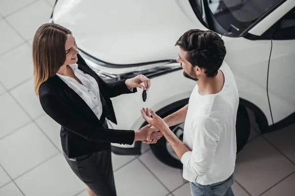 Vendedor con cliente en concesionario de coches — Foto de Stock