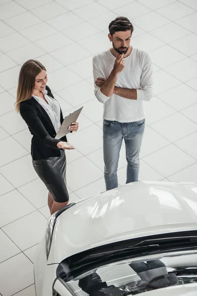 Vendedor con cliente en concesionario de coches — Foto de Stock