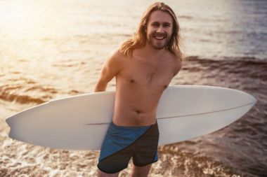 Sörf tahtası olan genç adam