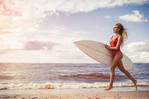 Mujer joven con tabla de surf —  Fotos de Stock