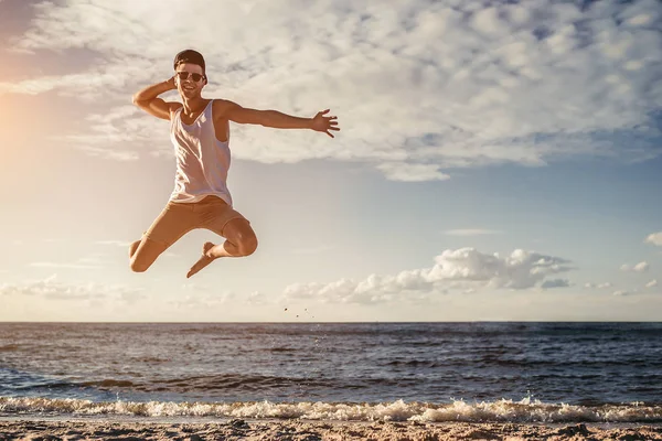 Ung man hoppa på stranden — Stockfoto