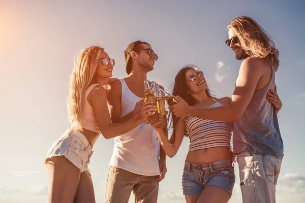 Vrienden drinken bier op strand — Stockfoto