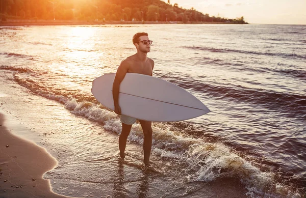 Sörf tahtası olan genç adam