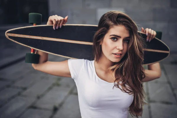 Adolescente feminina com skate — Fotografia de Stock