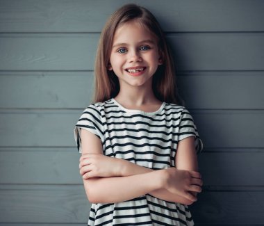 Gri arka planda sevimli küçük bir kız