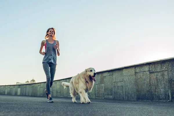 Mujer corriendo con perro — Foto de Stock