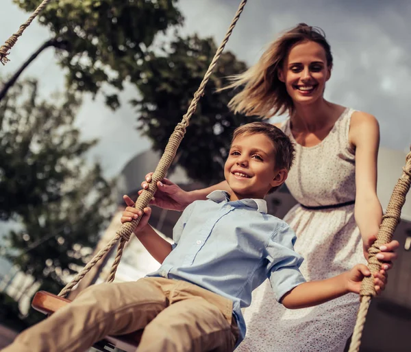 Moeder met zoon op schommel — Stockfoto