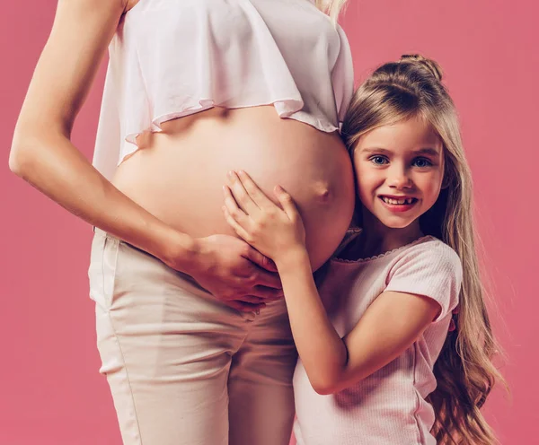 Kobieta w ciąży z córką na białym tle — Zdjęcie stockowe