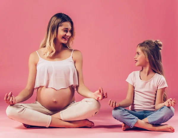 Kobieta w ciąży z córką na białym tle — Zdjęcie stockowe