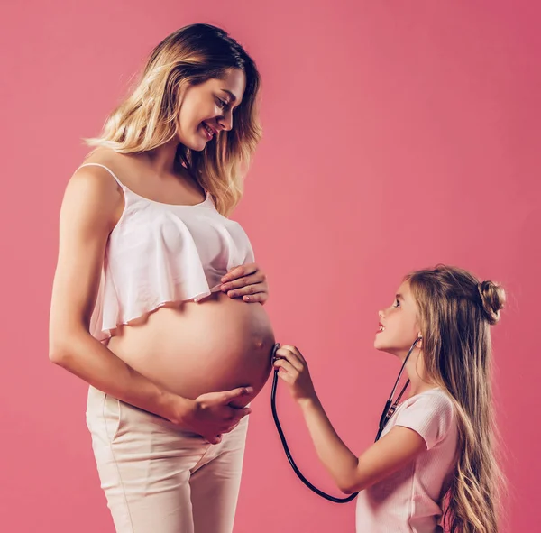 Mulher grávida com filha isolada — Fotografia de Stock