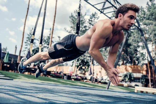 Hombre deportivo en TRX — Foto de Stock