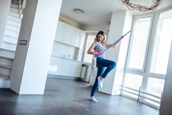 Mujer joven está haciendo limpieza en casa — Foto de Stock