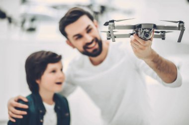 Dad and son in quadcopter store clipart