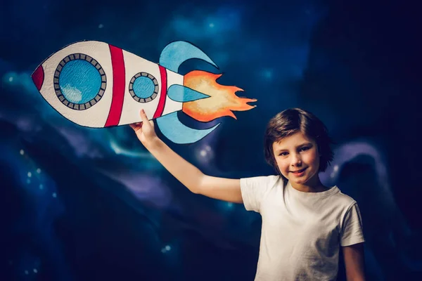 Menino com foguete de brinquedo no espaço — Fotografia de Stock