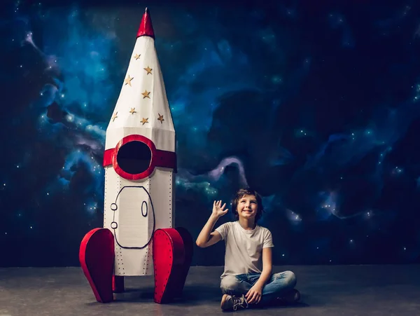 Menino com foguete de brinquedo no espaço — Fotografia de Stock