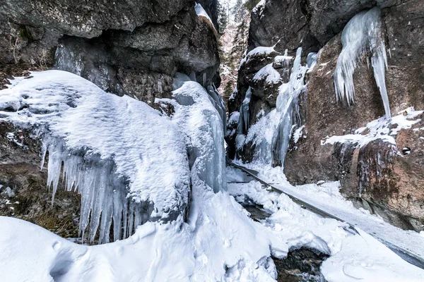 Sentier pédestre à travers une gorge étroite couverte de neige et de glace . — Photo