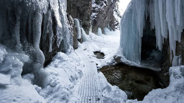 Sentier pédestre à travers une gorge étroite couverte de neige et de glace . — Photo