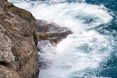 Dalgalar kayalık deniz sahilinde.