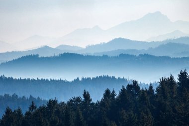 Hava perspektifi ile ayrılmış dağ sırtlarının görüntüsü.