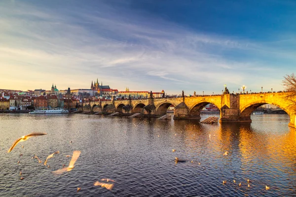 Karlsbrücke mit Prager Burg im Hintergrund bei Sonnenuntergang. — Stockfoto