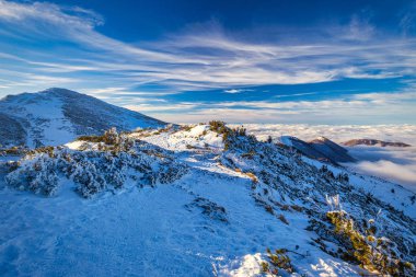 Güneşli bir günde, vadilerde sisli bir kış manzarası