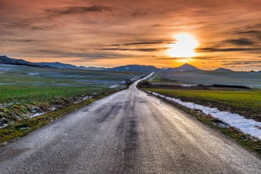 Gün batımında dağ vadisinde bir yol.