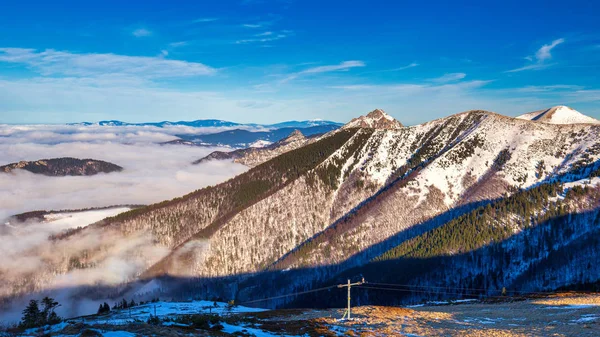 Paisaje montañoso invernal en un día soleado con niebla en los valles — Foto de Stock