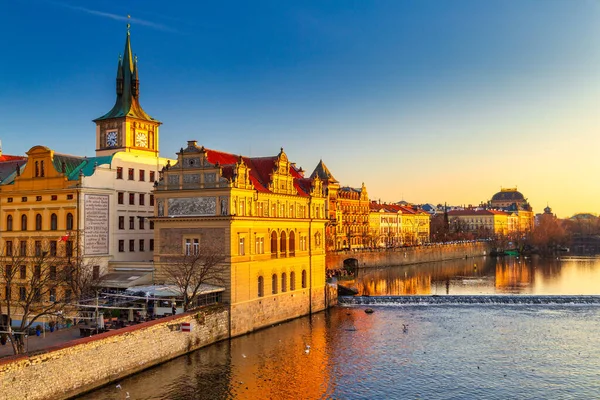Bâtiments historiques sur la rive de la rivière Vltava au coucher du soleil à Prague . — Photo