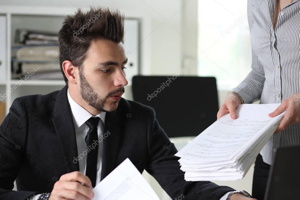 Female employee show pack of documents to manager