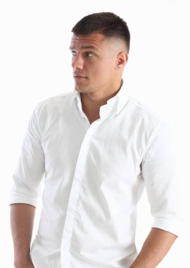 Beyaz zemin üzerinde bir tişörtlü yakışıklı adam. Çekici ve başarılı görünüyor