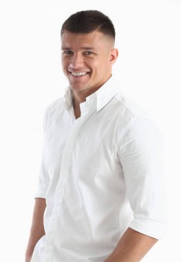 Beyaz gömlekli başarılı iş adamı gülümsüyor ve kameraya benziyor