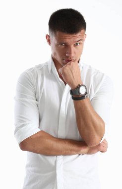 Bir adam elini çenesine için beyaz bir arka planda tutar. Kameraya bakmak gibi davranarak