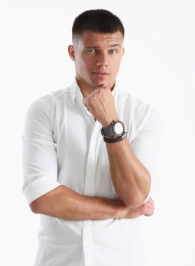 Bir adam elini çenesine için beyaz bir arka planda tutar. Kameraya bakmak gibi davranarak