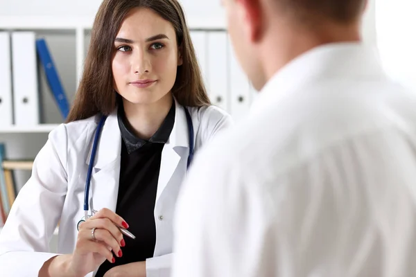 Bonita sorridente fêmea médico segurar caneta de prata — Fotografia de Stock