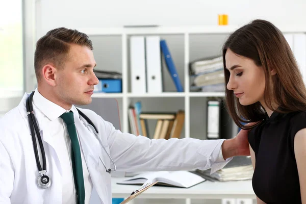 Friendly male doctor hold patient shoulder in office