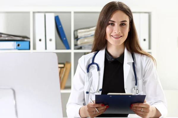 Beautiful smiling female doctor hold clipboard pad — Stock Photo, Image