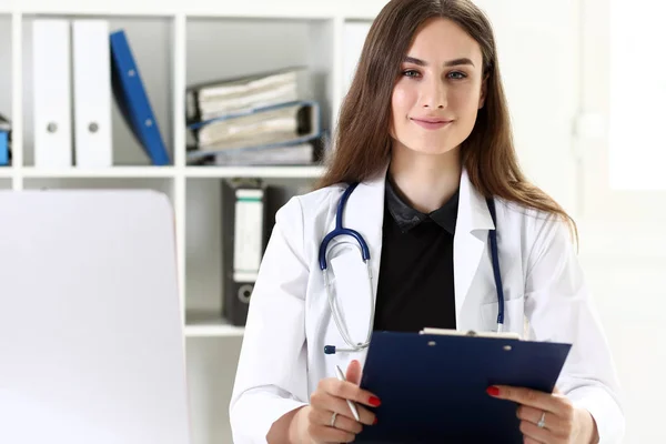 Krásný, usmívající se ženský lékař držet schránky podložka — Stock fotografie