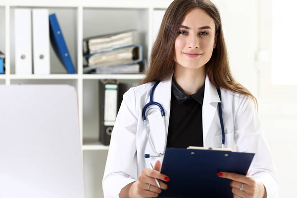 Beautiful smiling female doctor hold clipboard pad