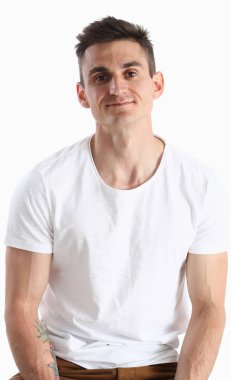 Bir sandalyede oturuyor ve gülümseyen bir T-shirt, çekici bir kadın portresi