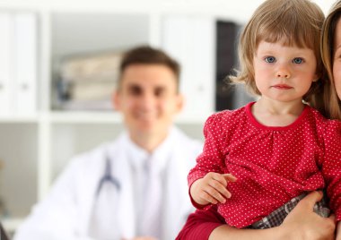 Küçük çocuk ile anne çocuk doktoru resepsiyonda